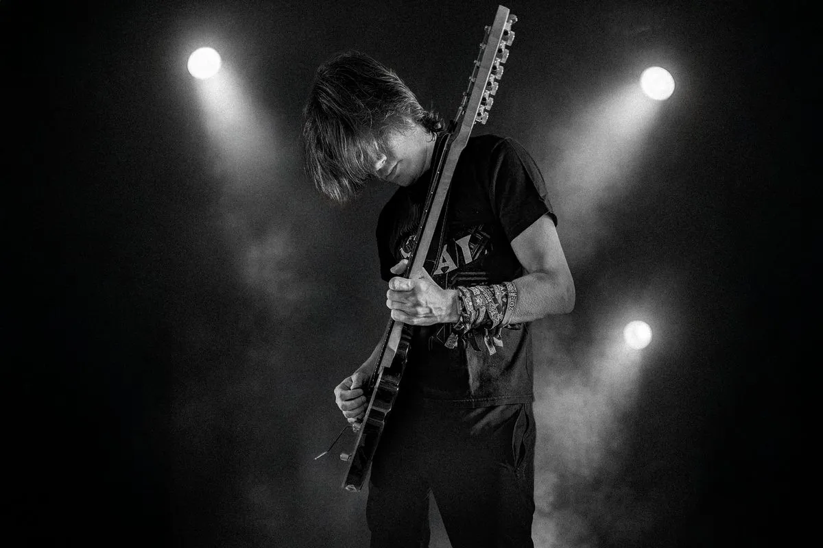 Guitarist with festival wristbands in stage light
